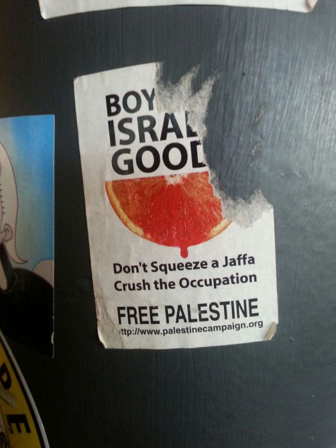 This sticker is calling for a boycott of goods from Israel, specifically oranges. The BDS (Boycott, Divestment, Sanctions) movement aims to resolve the Israel-Palestine issue by exerting economic pressure. 